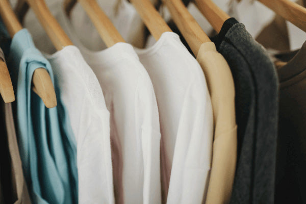 A colourful rack of shirts neatly hanging on a clothesline, showcasing various styles and patterns in a sunny outdoor setting